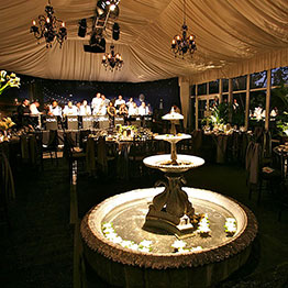 Inside of Tented Pavilion with decorative water fountain and live band at night